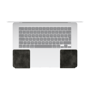 Top view of a silver MacBook with two dark ChronoPad palm rest pads on either side of the trackpad